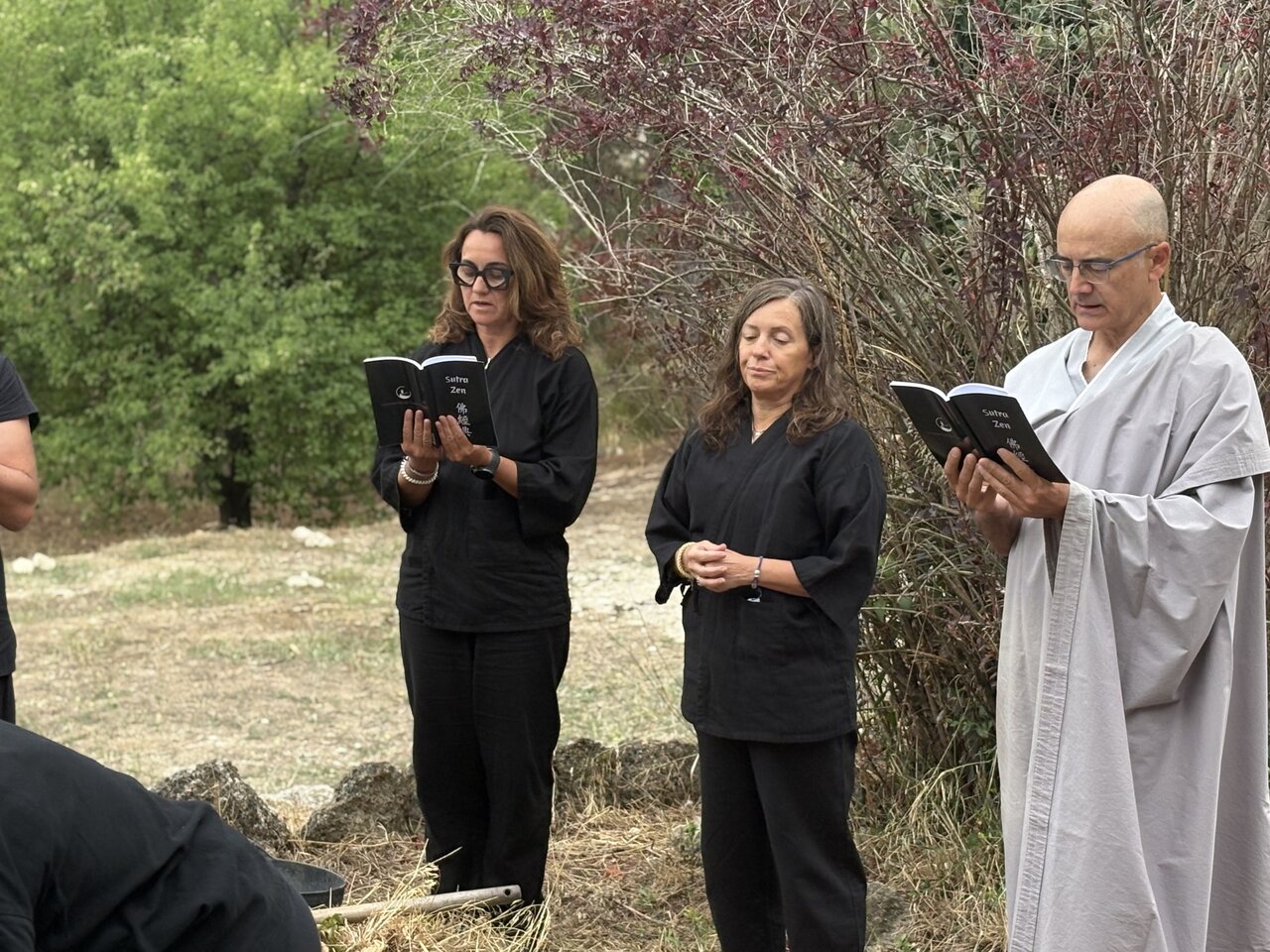 Tres personas leyendo la ofrenda durante la ceremonia